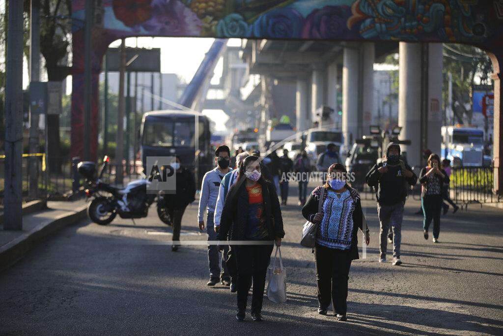 Fernando Llano Commuters, looking for an alternate form of transportation, walk near a collapsed elevated section of the subway, in Mexico City, Tuesday, May 4, 2021. The elevated section of the metro collapsed and sent rail cars plunging toward a busy boulevard late Monday, killing at least 23 people and injuring at least 79, city officials said. (AP Photo/Fernando Llano)