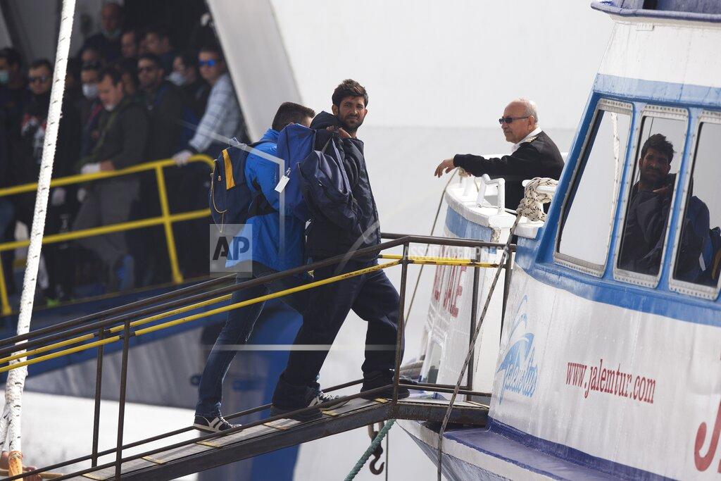 Petros Giannakouris FILE - In this Friday, April 8, 2016 file photo, an officer from the European Union's border protection agency, Frontex, leads a migrant on board to a ferry in the port of Mytilini, Lesbos island, Greece. Five years on, the deal between European Union and Turkey is no longer working but at a summit next week EU leaders will discuss ways to improve relations with Turkey and could try to revive the agreement. (AP Photo/Petros Giannakouris, File)