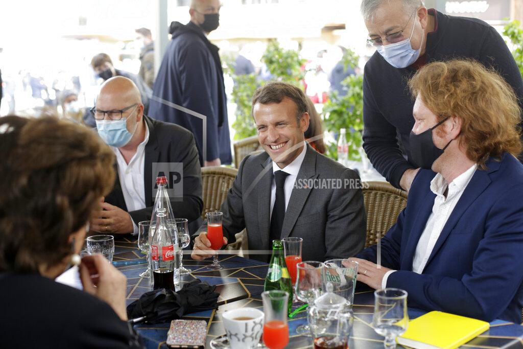 Thibault Camus French President Emmanuel Macron shares a drink with shopkeepers during a visit to mark the reopening of cultural activities after closures during the Covid-19 pandemic, in Nevers, central France, Friday, May 21, 2021. (AP Photo/Thibault Camus, Pool)