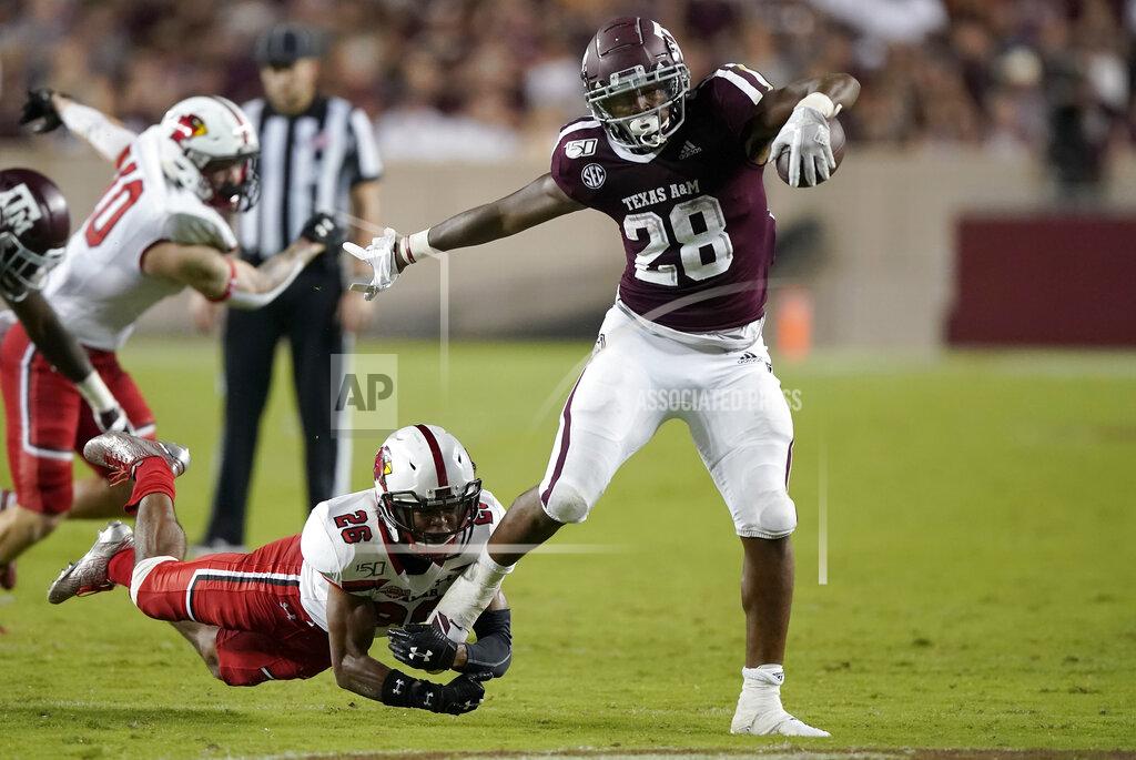 Texas A&M running back Isaiah Spiller (28) shakes off a tackle by Lamar defensive back Tariq Gordon (26) during a touchdown run in the second half of an NCAA college football game, Saturday, Sept. 14, 2019, in College Station, Texas. (AP Photo/Sam Craft)