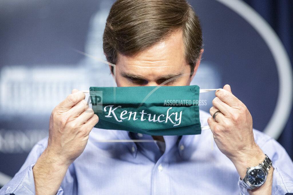 FILE - In this May 11, 2020, file photo, Kentucky Gov. Andy Beshear puts on a face mask after speaking to reporters at the Capitol in Frankfort, Ky. Kentucky's governor said Sunday, Oct. 11, 2020, that he will quarantine after a member of his security detail who drove with his family the day before later tested positive for COVID-19.
Democratic Gov. Andy Beshear said he and his family feel fine, show no coronavirus symptoms and have tested negative for the virus. (Ryan C. Hermens/Lexington Herald-Leader via AP, File)