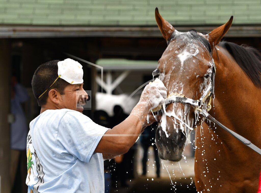 Timothy D. Easley FILE - In this April 19, 2017 file photo, groom Cesar Abrego gives a bath to one of the horses being trained by Dale Romans following his morning workout at Churchill Downs in Louisville, Ky. Abrego came from Guatemala on an H-2B visa. The Trump administration’s immigration squeeze and the hardships caused by the coronavirus pandemic threaten to leave the horse racing industry short of workers, racing officials warn as they prepare for a reconfigured Kentucky Derby. (AP Photo/Timothy D. Easley)
