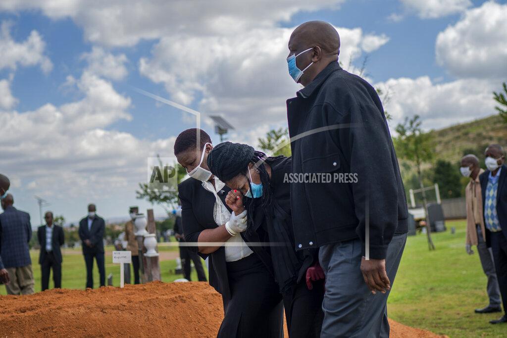 Jerome Delay Relatives grieve Benedict Somi Vilakasi at his burial ceremony at the Nasrec Memorial Park outside Johannesburg Thursday, April 16, 2020. Vilakasi, a Soweto coffee shop manager, died of COVID-19 infection in a Johannesburg hospital Sunday April 12, 2020. South Africa is under a strict five-week lockdown in a effort to fight the Coronavirus pandemic. (AP Photo/Jerome Delay)