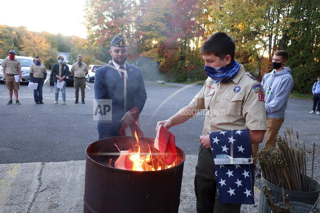 Ted Shaffrey FILE - In this Tuesday, Oct. 13, 2020 file photo, Jondavid Longo, Republican mayor of Slippery Rock, Pa., center, presides over a Boy Scouts flag retirement ceremony where worn out flags are cut up and burned in Slippery Rock. Longo says the 2020 election has changed politics in his town, surfacing resentments from voters on both sides. The lingering tensions now overshadow issues once considered local — such as funding the police and libraries. (AP Photo/Ted Shaffrey)