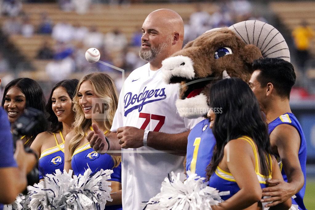 Mark J. Terrill Former Los Angeles Rams offensive lineman Andrew Whitworth, center, poses with members of the Rams cheerleader squad and Rams mascot Rampage before throwing out the ceremonial first pitch prior to a baseball game between the Dodgers and the San Francisco Giants Tuesday, Sept. 6, 2022, in Los Angeles. (AP Photo/Mark J. Terrill)