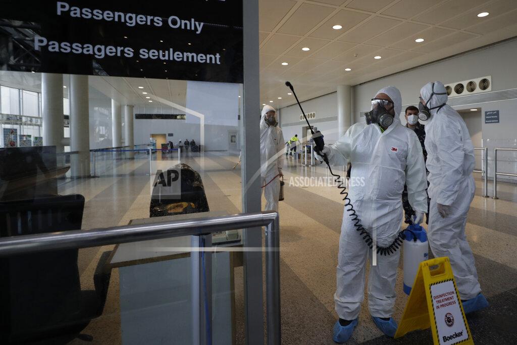 Hassan Ammar FILE - In this March 5, 2020 file photo, workers wearing protective gear spray disinfectant as a precaution against the coronavirus outbreak, in the departure terminal at the Rafik Hariri International Airport, in Beirut, Lebanon. On Wednesday, July 1, 2020, Beirut's airport is partially reopening after a three-month shutdown and Lebanon's cash-strapped government hopes thousands of Lebanese expatriates will return for the summer, injecting badly needed dollars into the sinking economy. (AP Photo/Hassan Ammar, File)