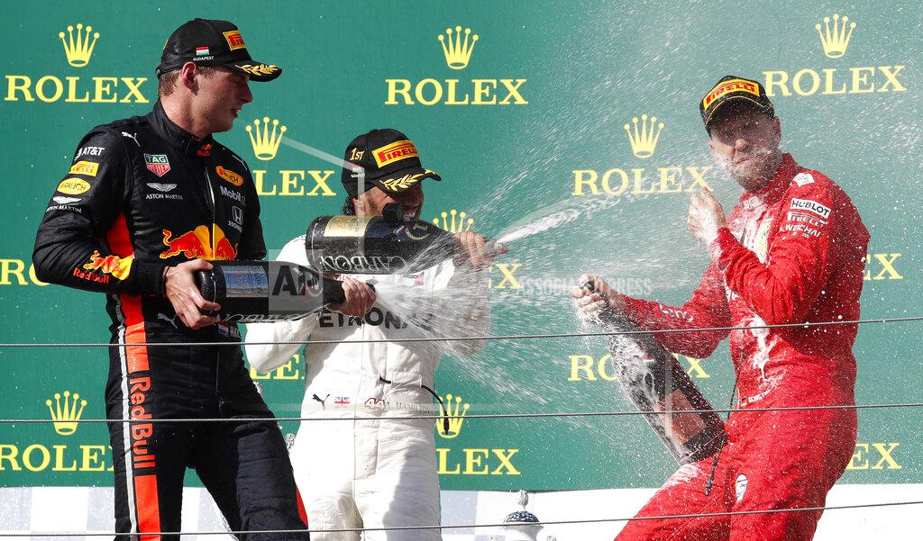 Laszlo Balogh Mercedes driver Lewis Hamilton, center, of Britain, winner of the Hungarian Formula One Grand Prix, celebrates on the podium with second placed Red Bull driver Max Verstappen, left, of the Netherlands, and third placed Ferrari driver Sebastian Vettel, of Germany, at the Hungaroring racetrack in Mogyorod, northeast of Budapest, Hungary, Sunday, Aug. 4, 2019. (AP Photo/Laszlo Balogh)