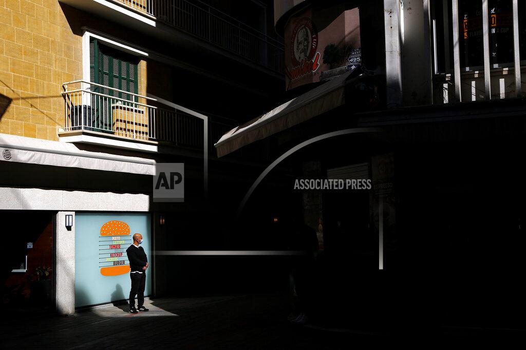 Petros Karadjias A man wearing a face mask stands outside a restaurant in central capital Nicosia, Cyprus, Friday, March 12, 2021. Cyprus put the breaks on a wider loosening of COVID-19 restrictions by keeping middle school students at home for two more weeks as the infection rate remains high partly because of how widespread the U.K. variant has become. (AP Photo/Petros Karadjias)