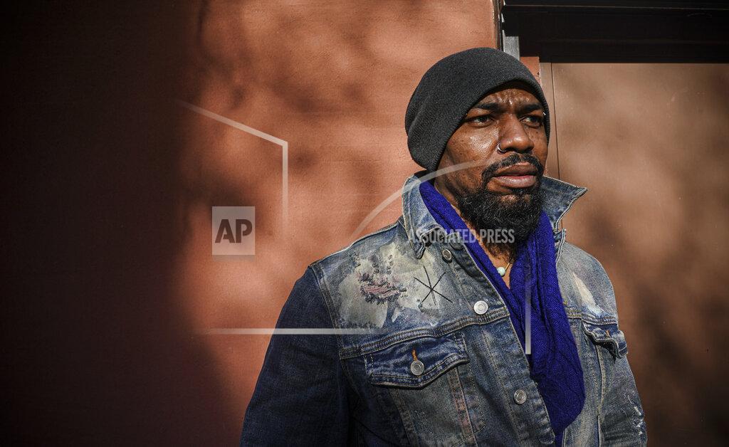 Bebeto Matthews Painter Guy Stanley Philoche, a 43-year-old Haitian immigrant and star in the New York art world, pose outside his East Harlem studio, Thursday Nov. 19, 2020, in New York. After a hugely successful gallery show, Philoche wanted to treat himself to a fancy $15,000 watch, instead he bought the works of fellow artists struggling in the pandemic. "I'm not a rich man," he said, "but I owe a big debt to the art world." (AP Photo/Bebeto Matthews)