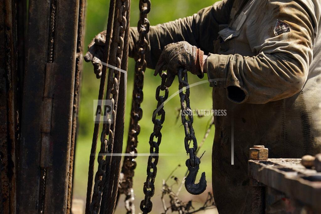 Eric Gay A well worker moves equipment at a site on the Rooke family ranch where an orphaned oil well was plugged, Tuesday, May 18, 2021, near Refugio, Texas. Oil and gas drilling began on the ranch in the 1920s and there were dozens of orphaned wells that needed to be plugged for safety and environmental protection. (AP Photo/Eric Gay)