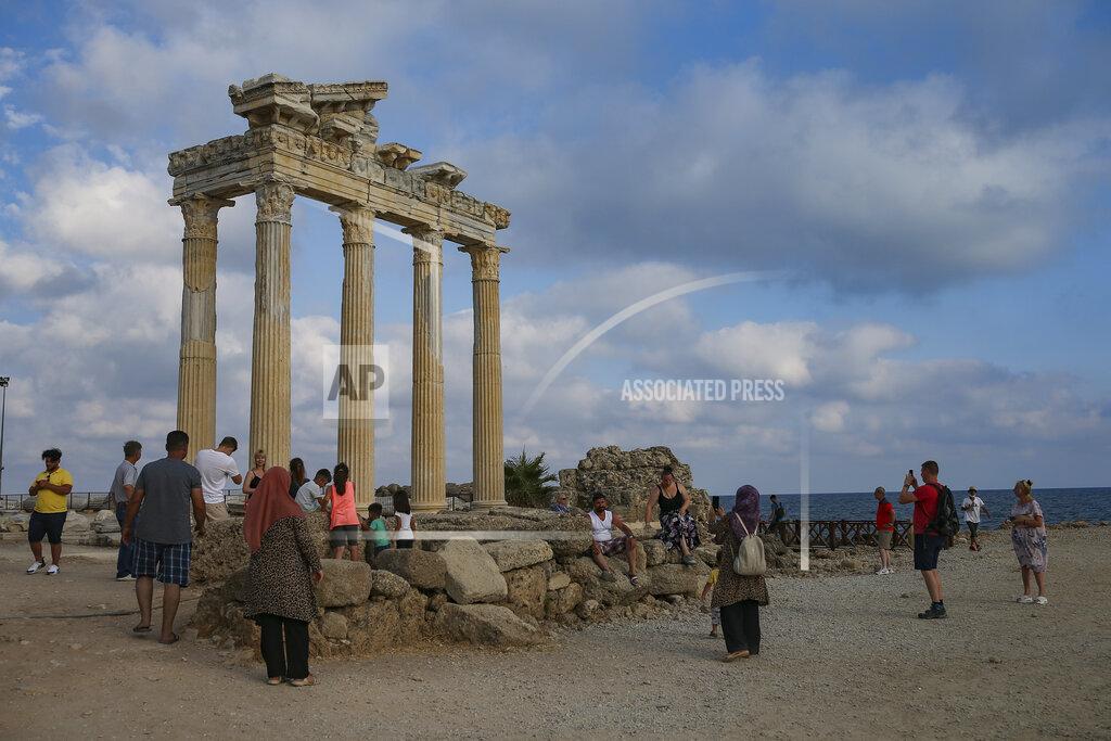 Emrah Gurel Tourists visit the 150A.D Roman temple dedicated to Apollo the Greek and Roman god of music, harmony and light, in Antalya, southern Turkey, on Sunday, June 20, 2021. Hotels in Turkey's Antalya region, a destination beloved by holidaymakers, are preparing to finally resume operations as they expect the return of international tourists after months of setbacks caused by the pandemic that halted travel. (AP Photo/Emrah Gurel)
