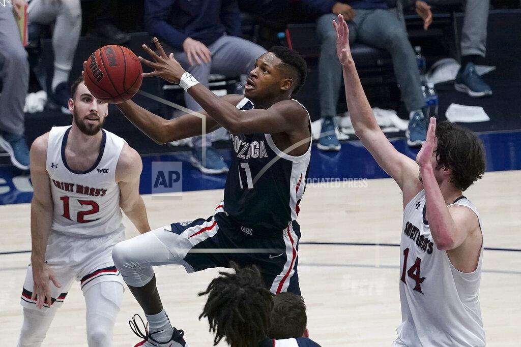 Jeff Chiu Gonzaga guard Joel Ayayi, middle, shoots between Saint Mary's guard Tommy Kuhse (12) and forward Kyle Bowen (14) during the first half of an NCAA college basketball game in Moraga, Calif., Saturday, Jan. 16, 2021. (AP Photo/Jeff Chiu)