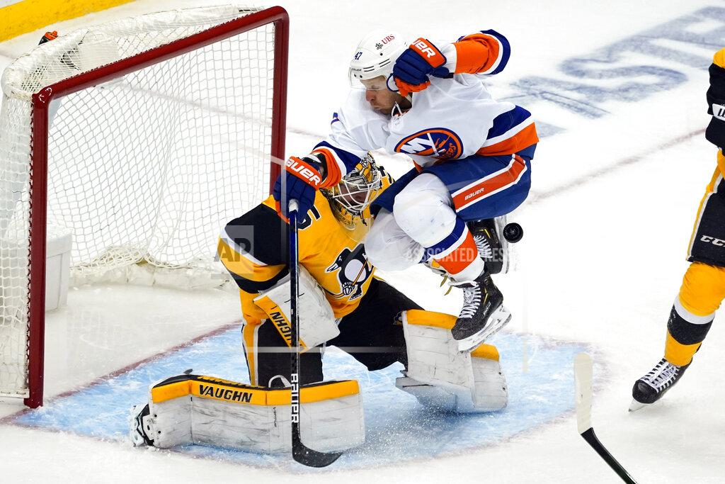 Gene J. Puskar New York Islanders' Leo Komarov (47) leaps but can't get out of the way of a shot in front of Pittsburgh Penguins goaltender Tristan Jarry during the third period in Game 1 of an NHL hockey Stanley Cup first-round playoff series in Pittsburgh, Sunday, May 16, 2021. (AP Photo/Gene J. Puskar)