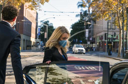 Elizabeth Holmes, center, leaves federal court in San Jose, Calif., Monday, Nov. 22, 2021. Elizabeth Holmes, the one-time medical entrepreneur now charged with building a fraudulent company based on promises of a revolutionary technology, returned to the witness stand Monday. (AP Photo/Nic Coury)
