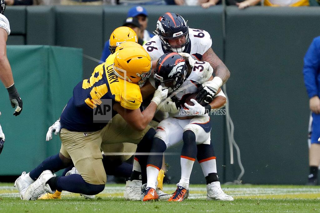 Matt Ludtke Denver Broncos running back Phillip Lindsay (30) fights his way past Green Bay Packers defensive end Dean Lowry (94) for a touchdown with the help of teammate offensive tackle Dalton Risner during the second half of an NFL football game Sunday, Sept. 22, 2019, in Green Bay, Wis. (AP Photo/Matt Ludtke)