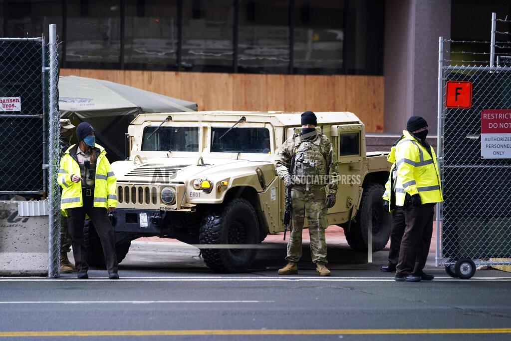 Jim Mone A National Guard soldier, center, stands guard with deputies at the restricted vehicle entrance of the Hennepin County Government Center, Thursday, April 8, 2021, in Minneapolis where testimony continues in the trial of former Minneapolis police officer Derek Chauvin. Chauvin is charged with murder in the death of George Floyd during an arrest last May in Minneapolis. (AP Photo/Jim Mone)