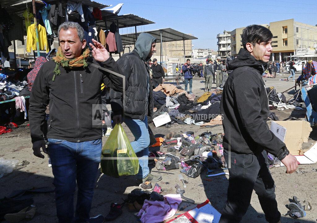 Hadi Mizban People and security forces gather at the site of a deadly bomb attack in Baghdad, Iraq, Thursday, Jan. 21, 2021. Iraq's military said twin suicide bombings at the Bab al-Sharqi commercial area in central Baghdad Thursday ripped through the busy market killing over two dozen and wounding over 70, with some in serious condition. (AP Photo/Hadi Mizban)