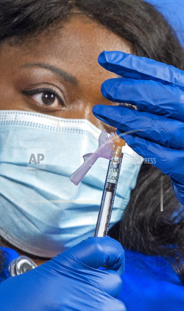 Nurse Meshoca Williams measures out a doses of the Pfizer-BioNTech COVID-19 vaccine for inoculation at Ochsner Hospital on O'Neal Lane, Tuesday, Dec. 15, 2020, in Baton Rouge, La. (Bill Feig/The Advocate via AP, Pool)