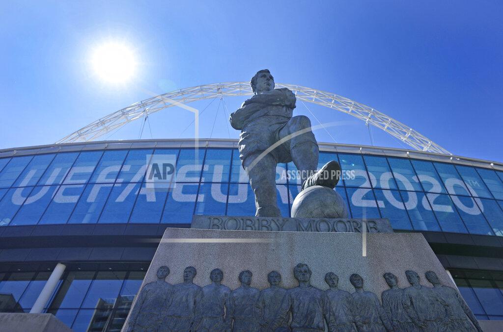 Frank Augstein FILE - In this Wednesday, June 9, 2021 file photo, a view of the statue of England's football legend Bobby Moore stands in front of the UEFA Euro sign, at Wembley stadium entrance, ahead of the Euro 2020 soccer championship in London. The British government says more than 60,000 fans will be allowed into the semifinals and final of the European Championship at Wembley Stadium. No details have been provided yet on how fans from overseas can attend without having to quarantine after flying into London. (AP Photo/Frank Augstein, File)
