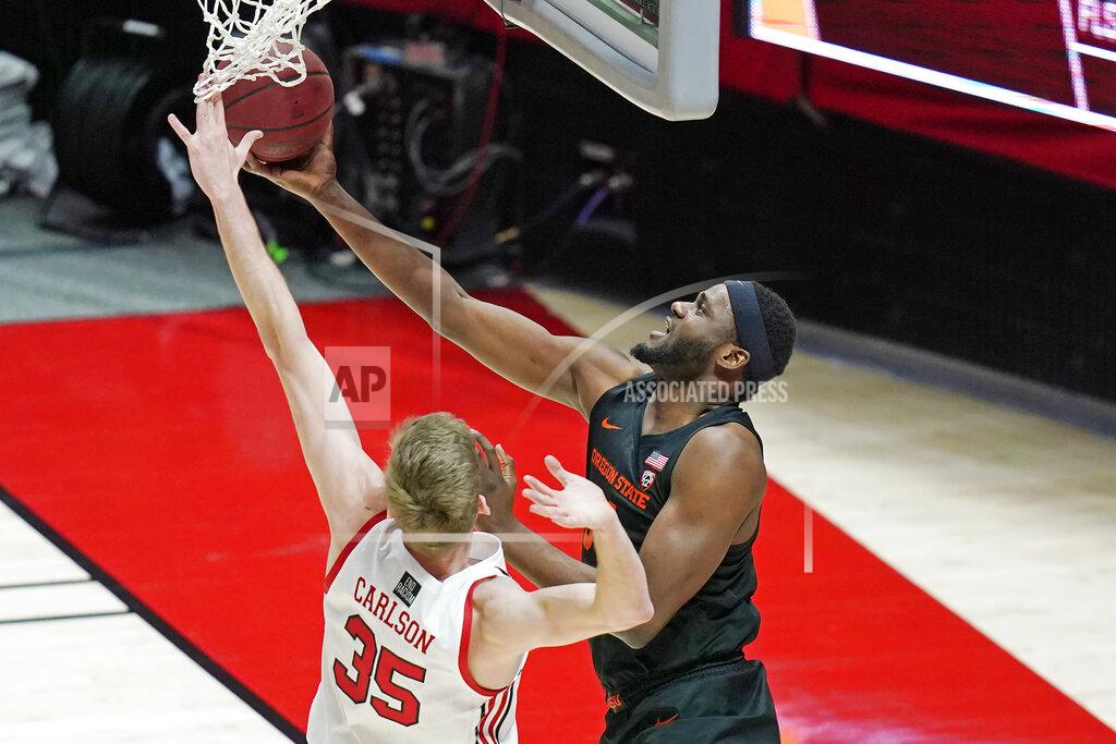 Rick Bowmer Oregon State forward Rodrigue Andela, right, lays the ball up as Utah center Branden Carlson (35) defends during the second half of an NCAA college basketball game Wednesday, March 3, 2021, in Salt Lake City. (AP Photo/Rick Bowmer)