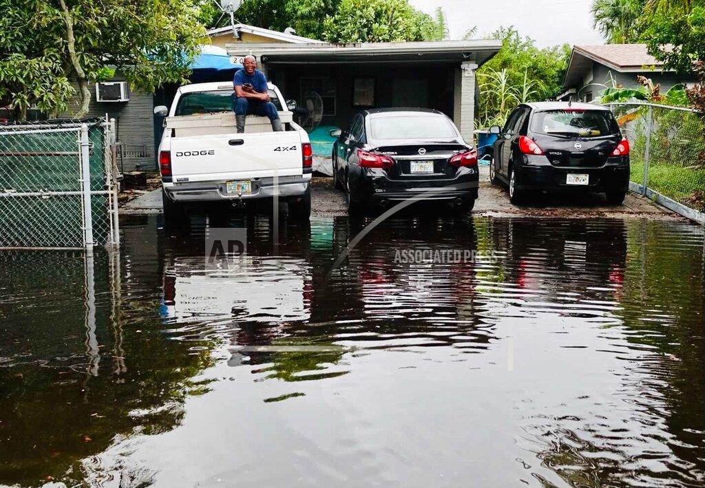 Joe Cavaretta A man sits in the bed of a truck as flooding is seen in the Melrose Manors neighborhood west of downtown Fort Lauderdale on Monday, Nov. 9, 2020. Tropical Storm Eta brought heavy rain and high winds to South Florida as it made landfall in the Florida Keys Sunday. (Joe Cavaretta/South Florida Sun-Sentinel via AP)