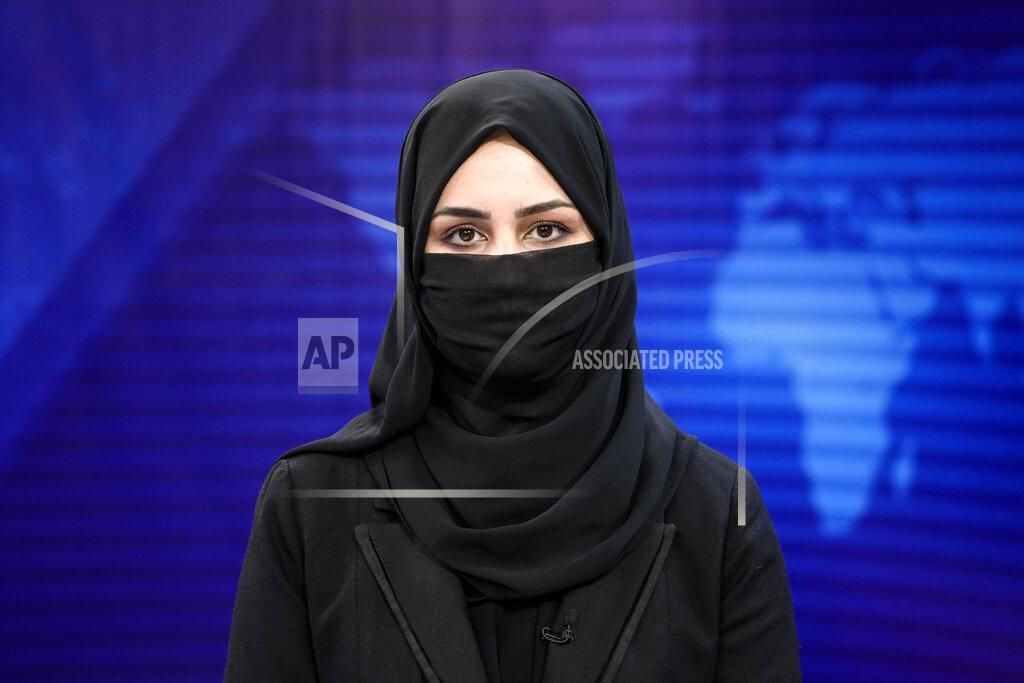 Ebrahim Noroozi Khatereh Ahmadi a TV anchor reads news on TOLO NEWS studio while covering her face, in Kabul, Afghanistan, Sunday, May 22, 2022. Afghanistan's Taliban rulers have begun enforcing an order requiring all female TV news anchors in the country to cover their faces while on-air. The move Sunday is part of a hard-line shift drawing condemnation from rights activists. (AP Photo/Ebrahim Noroozi)