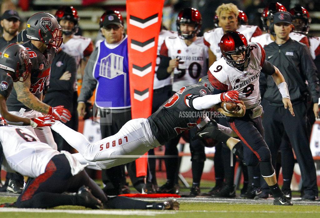Andres Leighton San Diego State quarterback Ryan Agnew (9) is slowed by New Mexico linebacker Sitiveni Tamaivena (26) during the first half of an NCAA college football game in Albuquerque, N.M., Saturday, Nov. 3, 2018. (AP Photo/Andres Leighton)
