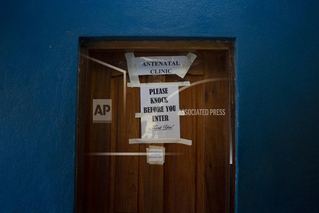 Leo Correa A sign taped on a door indicates an antenatal clinic office in a health unit where several women look for assistance for their prenatal care in Koidu, district of Kono, Sierra Leone, Tuesday, Nov. 24, 2020. In Sierra Leone, the rate of marriage under 18 had dropped from 56% in 2006 to 39% in 2017 _ a major achievement in the eyes of child protection activists. Then COVID-19 hit, schools closed in March and child marriages accelerated as many village girls who had been attending classes in nearby towns returned home to their parents. (AP Photo/Leo Correa)