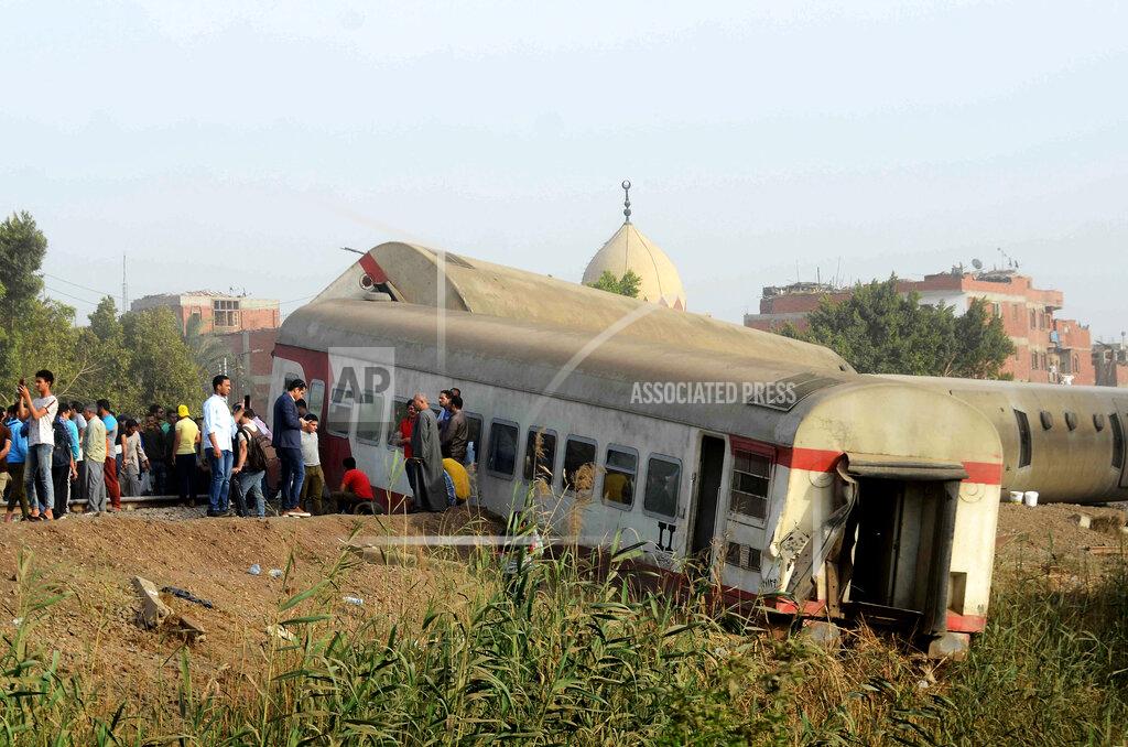 Tarek Wagih People gather at the site where a passenger train derailed injuring at least 100 people, near Banha, Qalyubia province, Egypt, Sunday, April 18, 2021. At least eight train wagons ran off the railway, the provincial governor's office said in a statement. (AP Photo/Tarek Wagih)