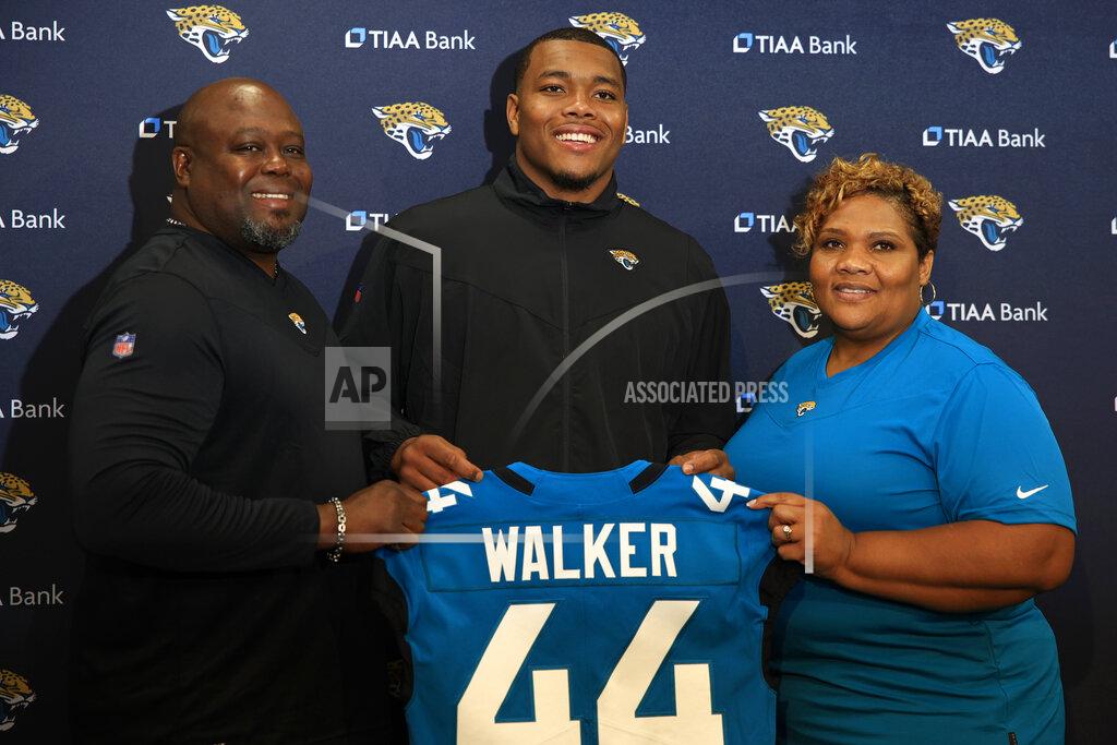 Corey Perrine Jacksonville Jaguars first round NFL football draft pick Travon Walker, center, is flanked by his father and mother, Stead Walker and Lasonia Walker, as he holds up his new jersey during a press conference, Friday, April 29, 2022 at TIAA Bank Field in Jacksonville, Fla. (Corey Perrine/The Florida Times-Union via AP)