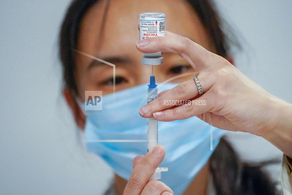 Mary Altaffer FILE - In this March 18, 2021, file photo, Pharmacist Mia Yu fills a syringe with the Moderna COVID-19 vaccine at a pop up site at Commonpoint Queens The Hub in partnership with the UJA- Federation of New York. Vaccines lessen the risk of severe illness or death from COVID-19, but scientists are still studying how well they prevent the spread of the virus. (AP Photo/Mary Altaffer, File)