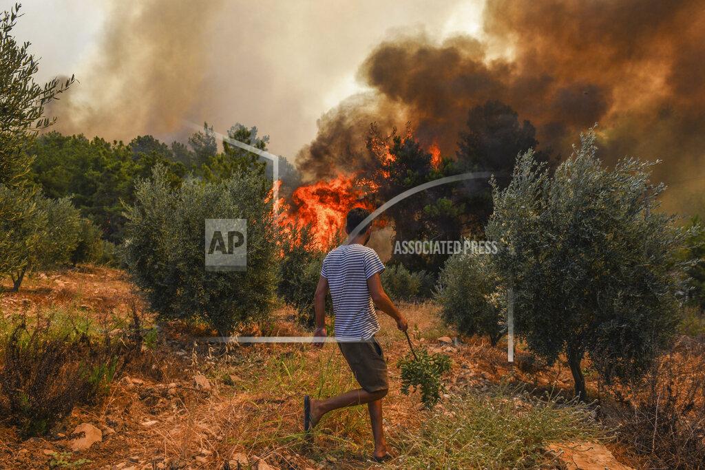 Uncredited A man walks toward wildfires in Kacarlar village near the Mediterranean coastal town of Manavgat, Antalya, Turkey, Saturday, July 31, 2021. The death toll from wildfires raging in Turkey's Mediterranean towns rose to six Saturday after two forest workers were killed, the country's health minister said. Fires across Turkey since Wednesday burned down forests, encroaching on villages and tourist destinations and forcing people to evacuate. (AP Photo)