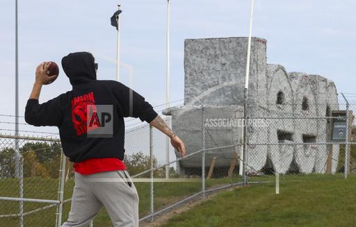 United Auto Workers union member Luke Strazzulla tosses a football during a strike along the south side of the Stellantis Toledo Assembly Complex on Friday, Oct. 13, 2023 in Toledo, Ohio. The United Auto Workers union expanded its strikes against Detroit automakers, ordering 7,000 more workers to walk off the job in Illinois and Michigan. The move announced Friday is supposed to put more pressure on the companies to improve their offers. (Phillip L. Kaplan/The Blade via AP)