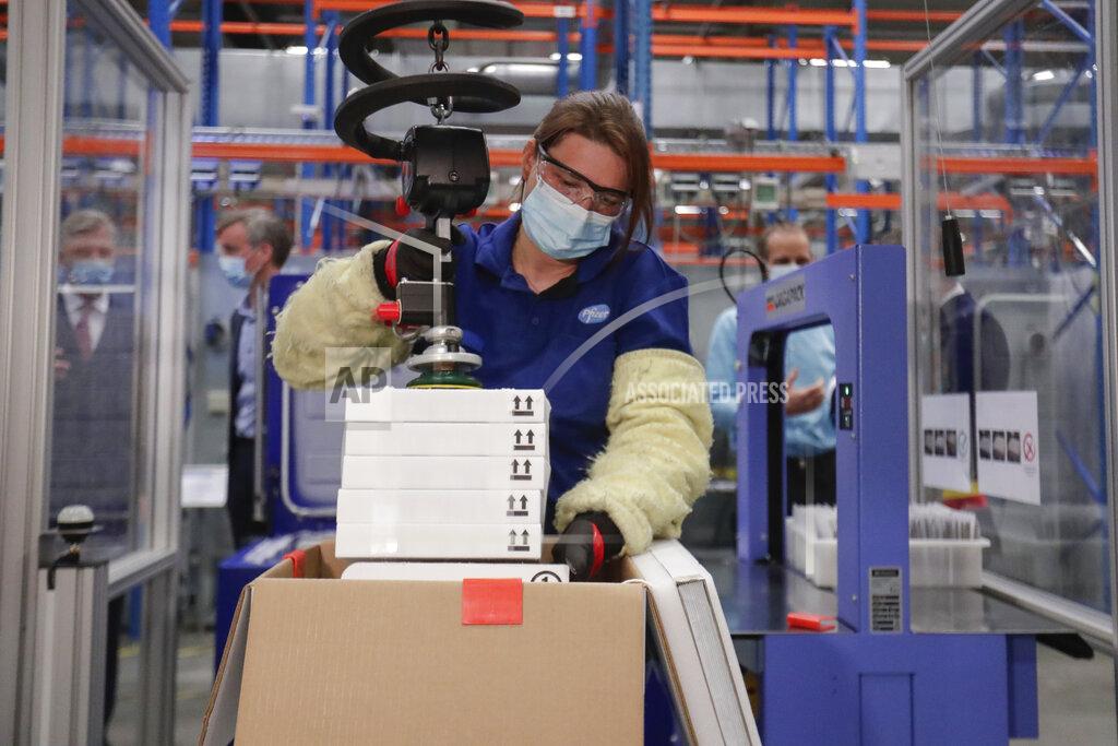 Stephanie Lecocq A worker uses a machine to pack boxes of the Pfizer COVID-19 vaccine doses during an official visit by Belgium's King Philippe to the Pfizer vaccine production site in Puurs, Belgium, Tuesday, March 30, 2021. (Stephanie Lecocq, Pool via AP)