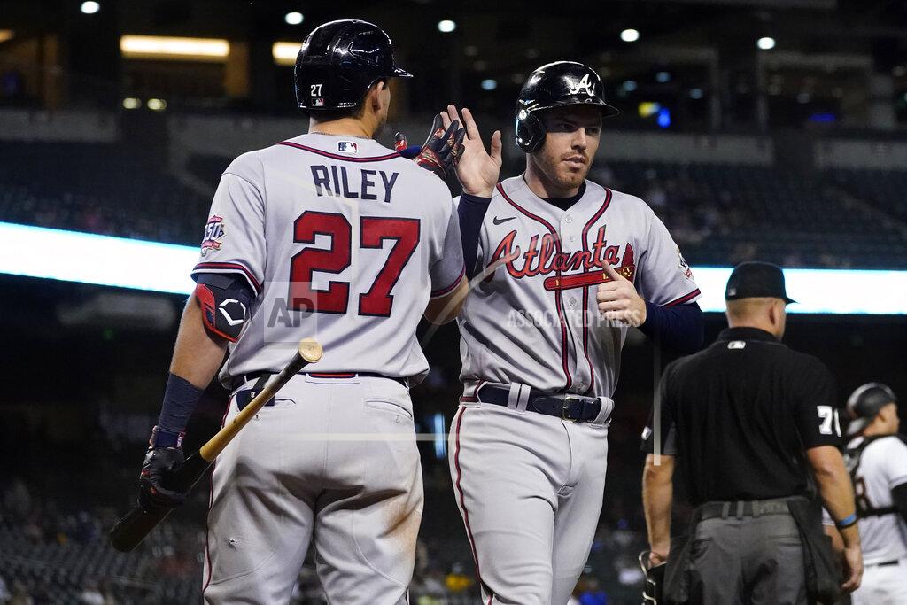 Matt York Atlanta Braves' Freddie Freeman high fives Austin Riley (27) after scoring on a double hit by Ozzie Albies during the fifth inning of a baseball game against the Arizona Diamondbacks, Monday, Sept. 20, 2021, in Phoenix. (AP Photo/Matt York)