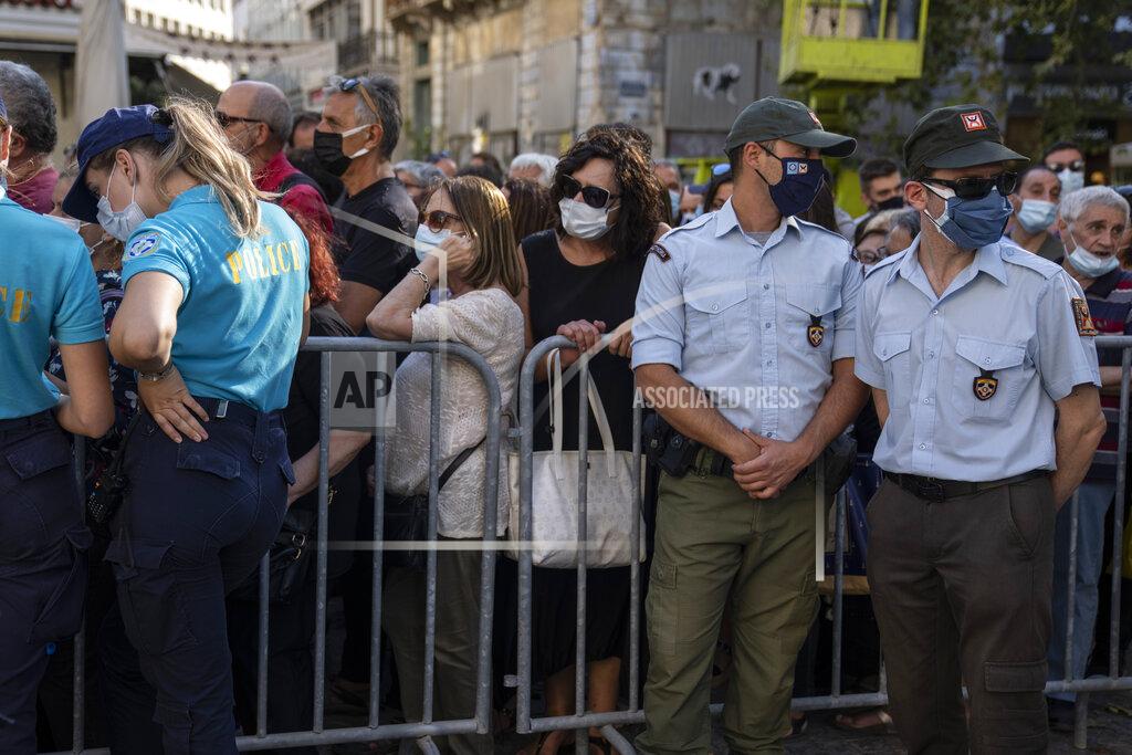 Petros Giannakouris People wait outside the Athens Cathedral to pay respect to the late Greek composer Mikis Theodorakis in Athens on Monday Sept. 6, 2021. Hundreds of people have gathered outside Athens Cathedral where Greek composer and politician Mikis Theodorakis is to lie in state in a chapel of the cathedral for three days ahead of his burial on the southern island of Crete. (AP Photo/Petros Giannakouris)