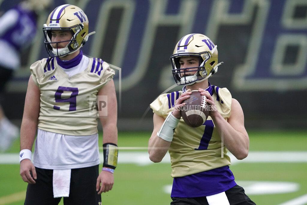 Ted S. Warren Washington quarterback Sam Huard, right, drops to pass next to quarterback Dylan Morris, left, during the first day of NCAA college football practice, Wednesday, April 7, 2021, in Seattle. (AP Photo/Ted S. Warren)