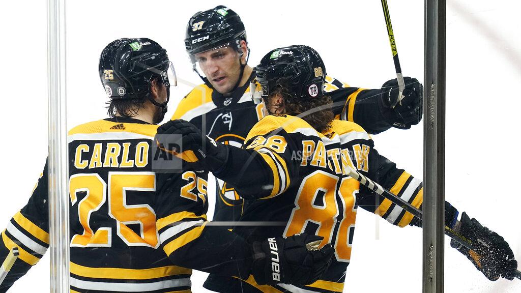 Charles Krupa Boston Bruins right wing David Pastrnak (88) is congratulated by Brandon Carlo (25) and Patrice Bergeron, center, after his goal against the Washington Capitals during the third period of an NHL hockey game, Wednesday, March 3, 2021, in Boston. (AP Photo/Charles Krupa)