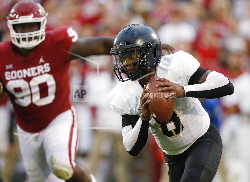 Sue Ogrocki FILE - In this Sept. 22, 2018, file photo, Army quarterback Kelvin Hopkins Jr. (8) carries past Oklahoma defensive lineman Neville Gallimore (90) in the first of an NCAA college football game, in Norman, Okla. A year ago quarterback Hopkin knew he wasn’t going to see much playing time under center for Army because starter Ahmad Bradshaw was having a stellar senior season for the Black Knights. Now, Hopkins is the lead man and has the demeanor he needs. (AP Photo/Sue Ogrocki, File)