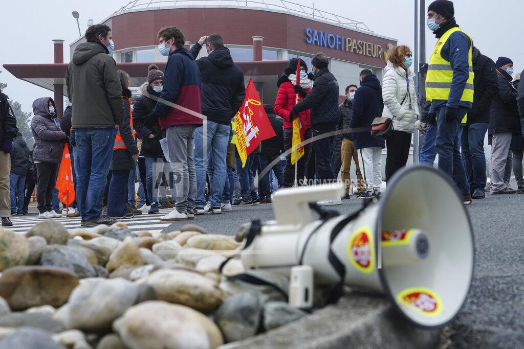 Laurent Cipriani Striking workers gather outside the French pharmaceutical company Sanofi headquarters in Marcy l'Etoile, central France, Tuesday, Jan.19, 2021. Employees of pharmaceutical company Sanofi stage a protest against planned redundancies that they say could slow the fight against the Coronavirus pandemic . Sanofi had been developing Covid vaccines but will not be ready to roll out until late 2021. (AP Photo/Laurent Cipriani)