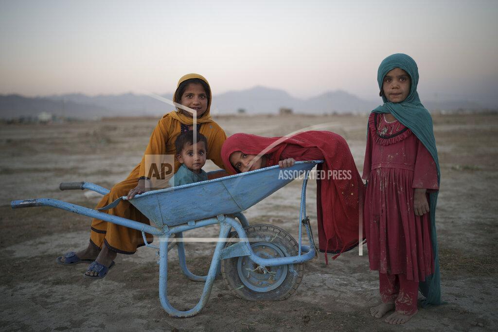 Felipe Dana FILE - In this Monday, Sept. 13, 2021 file photo, children pose for a photo as they play in a camp for internally displaced people in Kabul, Afghanistan. A month after the fall of Kabul, the question of how the world will get aid to citizens without enriching Afghanistan's Taliban rulers is haunting the country. The stakes have soared for Afghans, who along with the threat of famine and a collapsing health care system face a looming crisis as winter approaches. (AP Photo/Felipe Dana, File)