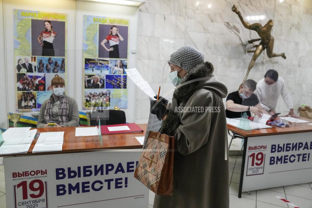 Pavel Golovkin A woman prepares to cast her ballot at a polling station during a parliamentary elections in Moscow, Russia, Friday, Sept. 17, 2021. Russia has begun three days of voting for a new parliament that is unlikely to change the country's political complexion. There's no expectation that United Russia, the party devoted to President Vladimir Putin, will lose its dominance in the State Duma. (AP Photo/Pavel Golovkin)