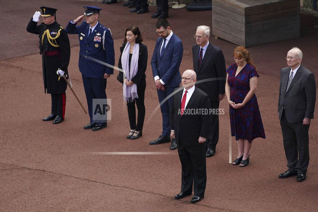 Steve Parsons Delegates from the United States Embassy including Acting Ambassador, Philip T Reeker, foreground, stand at the Guard Change at Windsor Castle, during a minute's silence to mark the 20th anniversary of the attack on the United States, in Windsor, England, Saturday, Sept. 11, 2021. Almost 3,000 people were killed when hijacked planes crashed into New York’s World Trade Center, the Pentagon in Washington and a field in Pennsylvania. (Steve Parsons/PA via AP)