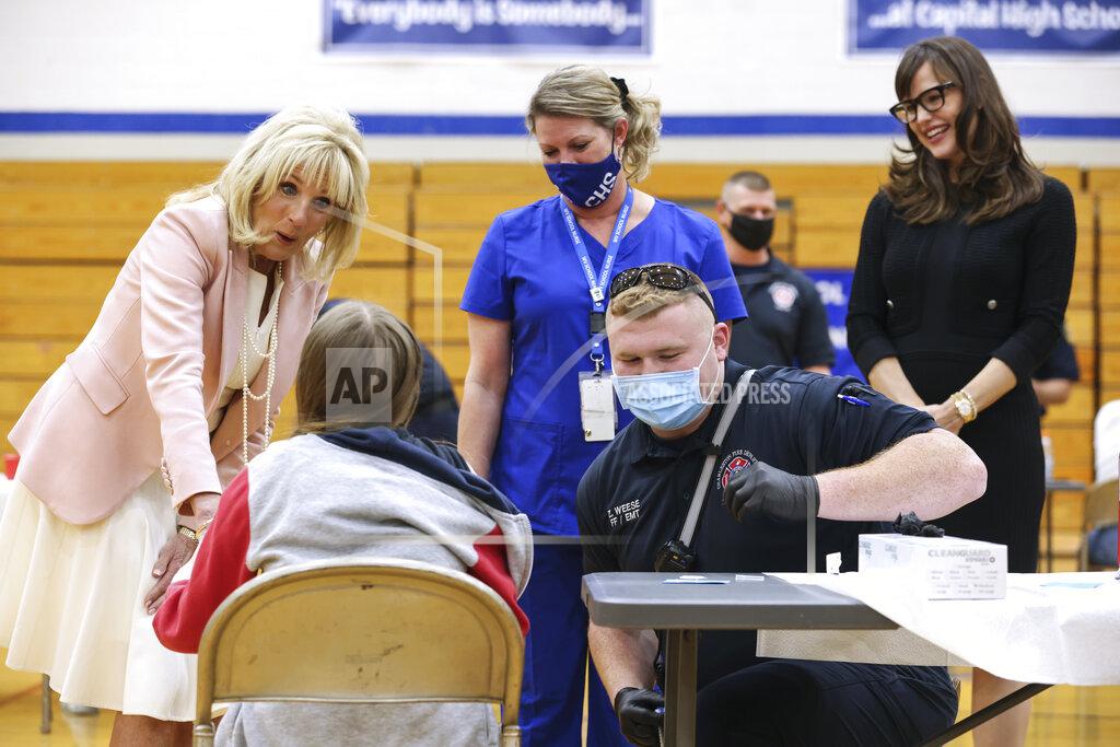 Oliver Contreras First lady Jill Biden and actress Jennifer Garner, right, speak to people being vaccinated for COVID-19 at Capitol High School in Charleston, W.Va., Thursday, May 13, 2021. (Oliver Contreras/The New York Times via AP, Pool)