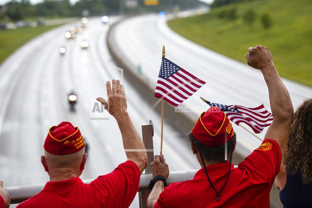 Sholten Singer Marine Corps League veterans wave as the funeral procession for Medal of Honor recipient Hershel "Woody" Williams moves along Interstate 64 on Saturday, July 2, 2022, in Teays Valley, W.Va. (Sholten Singer/The Herald-Dispatch via AP)