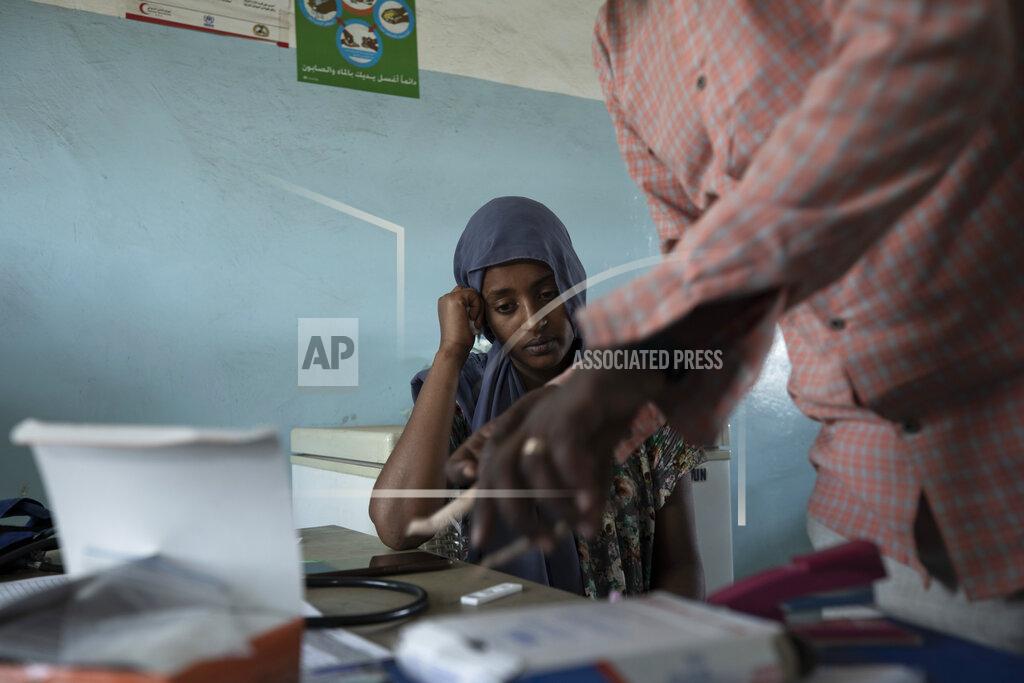 Nariman El-Mofty Surgeon and doctor-turned-refugee, Dr. Tewodros Tefera, prepares a malaria test for 23-year-old Tigrayan refugee Hareg from Mekelle, Ethiopia, at the Sudanese Red Crescent clinic in Hamdayet, eastern Sudan, near the border with Ethiopia, on March 17, 2021. (AP Photo/Nariman El-Mofty)