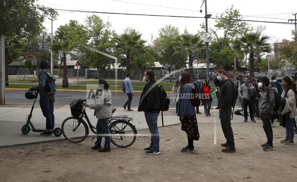 Esteban Felix People line up for their turn to vote during a referendum to decide whether the country should replace its 40-year-old constitution, in Santiago, Chile, Sunday, Oct. 25, 2020.(AP Photo/Esteban Felix)