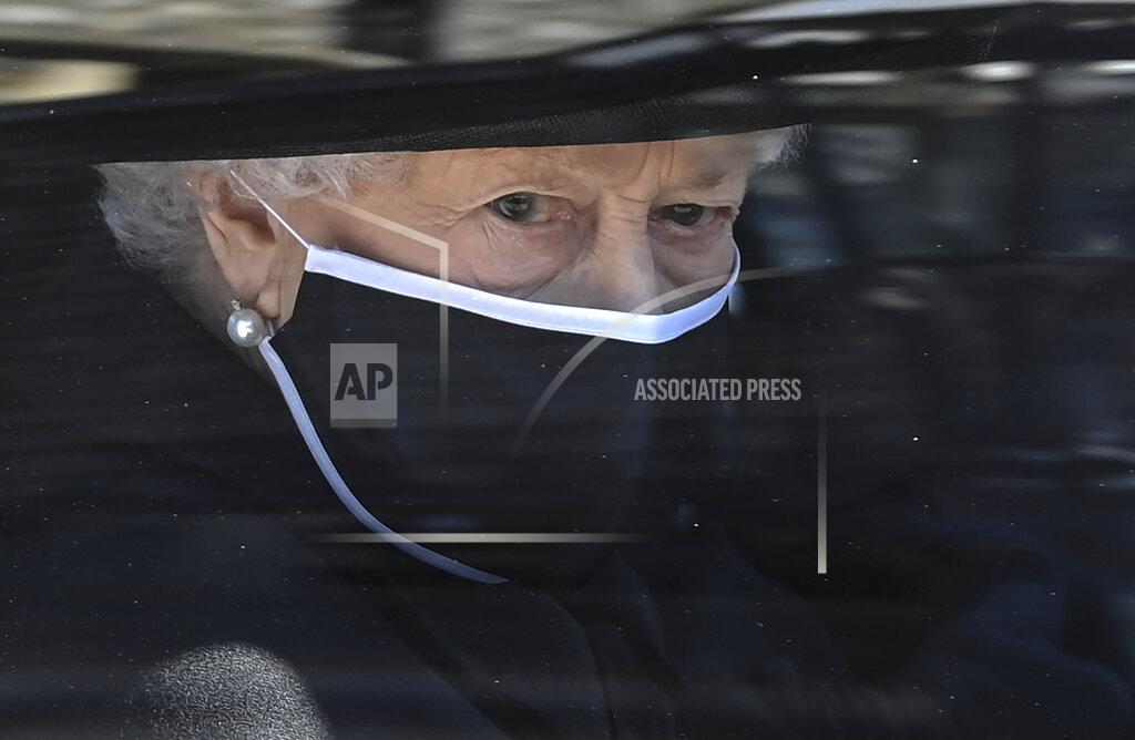 Leon Neal Britain's Queen Elizabeth II follows the coffin in a car as it makes it's way past the Round Tower during the funeral of Britain's Prince Philip inside Windsor Castle in Windsor, England Saturday April 17, 2021. (Leon Neal/Pool via AP)