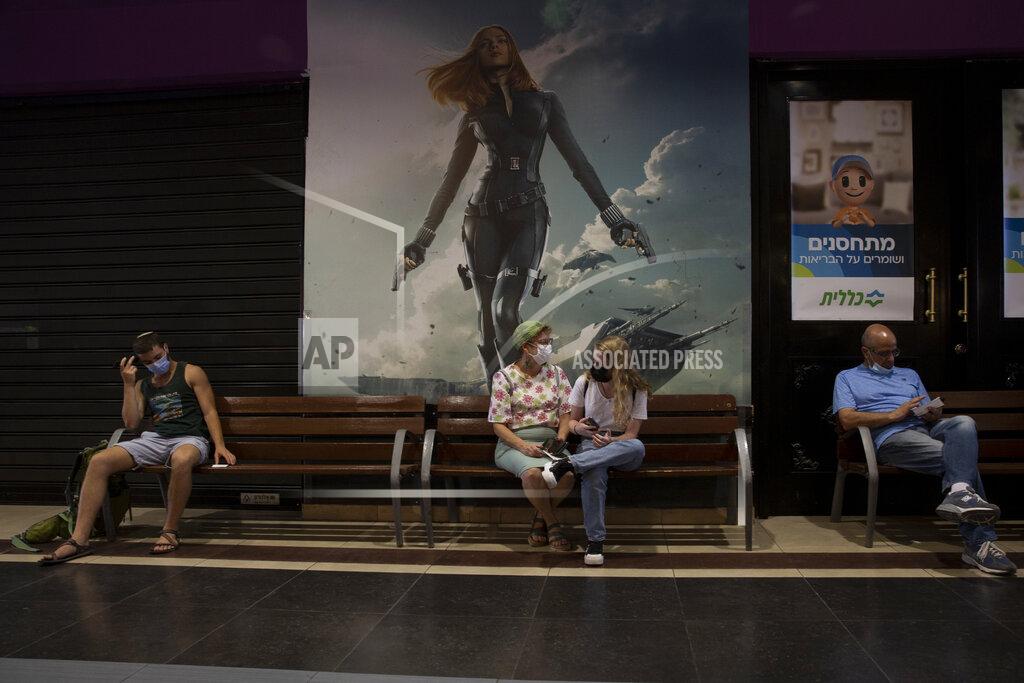 Maya Alleruzzo FILE - In this Aug. 15, 2021, file photo, Israelis wait their turn for a booster shot of the coronavirus vaccine, at Clalit Health Services, one of Israel's health maintenance organizations, at a cinema complex, in Jerusalem. Israel is pressing ahead with its aggressive campaign of offering coronavirus boosters to almost anyone over 12 and says its approach was further vindicated by a U.S. decision to give the shots to older patients or those at higher risk. (AP Photo/Maya Alleruzzo, File)
