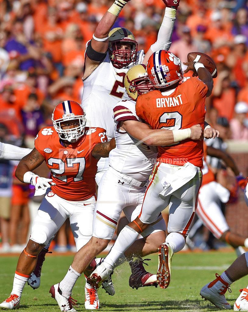 Clemson quarterback Kelly Bryant is pressured in the backfield by Boston College's Kevin Bletzer, front, and Zach Allen during the first half of an NCAA college football game, Saturday, Sept. 23, 2017, in Clemson, S.C. (AP Photo/Richard Shiro)